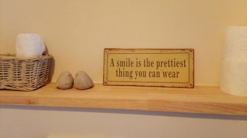 a sign on a shelf with a smile is the quickest thing you can wear at Chez Paulette in Avelgem