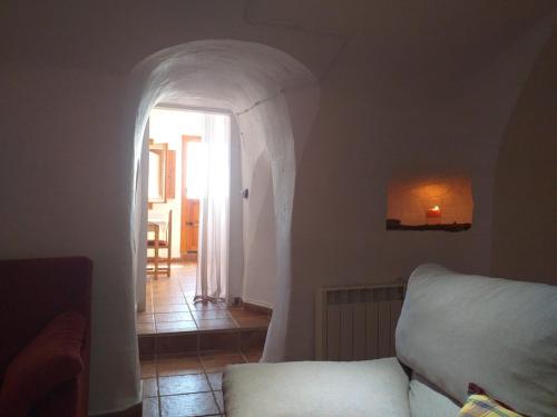 a living room with a bed and an archway at Casa Cueva Sol in Pozo Alcón