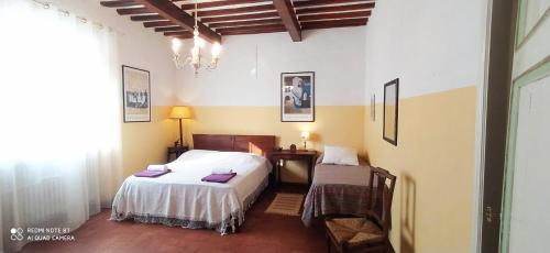 a bedroom with a bed and a desk and a bed sidx sidx sidx at la stanza del sole in Matraia