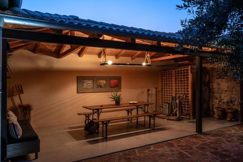 patio z drewnianym stołem i stołem w obiekcie Boutique Stone Cottage w mieście Dhímaina