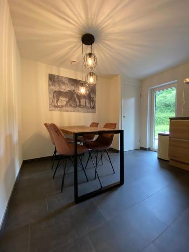 a dining room with a table and chairs at Vakantielodges Wissengracht in Hulsberg
