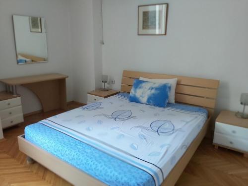 um quarto com uma cama com um edredom azul em Petar's Apartment Centar em Skopje