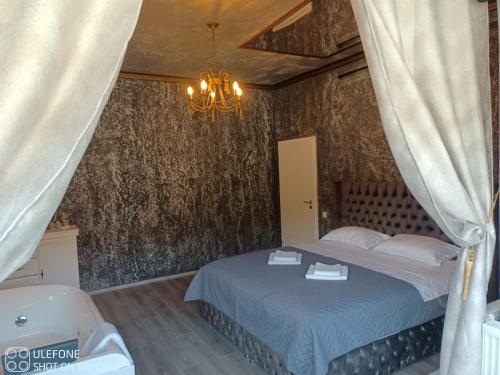 a bedroom with a bed and a chandelier at Valeria's Nest in Reşiţa