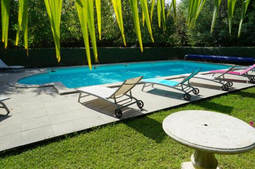 - une piscine avec deux chaises, une table et une table dans l'établissement Hotel Residence Bellevue, à Cambo-les-Bains