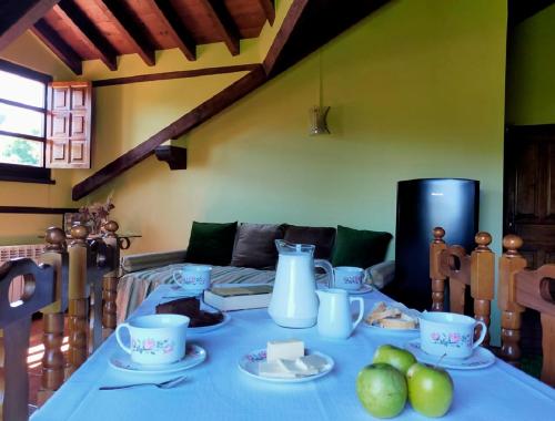 a table with a blue table cloth and plates of food at La Riguera De Ucieda in Ucieda de Arriba