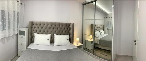 una camera con un grande letto e uno specchio di The Nest Apartment a Città di Zante