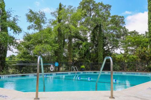 a swimming pool with blue water and trees at Bohicket Marina Condo in Seabrook Island