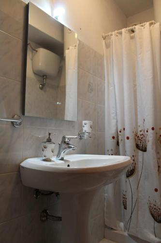 uma casa de banho com um lavatório e um espelho em VillaRosa em Lotzorai
