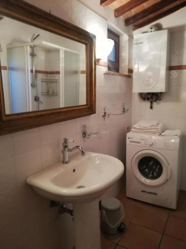 a bathroom with a sink and a washing machine at Casa Crevole in Palazzina