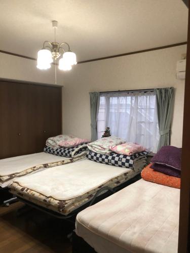 pokój z 3 łóżkami i oknem w obiekcie Youyousanso Modern B w mieście Tsu