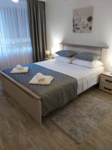 a bedroom with a large bed with towels on it at Apartman Alma in Bihać