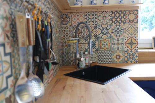 cocina con fregadero y encimera con azulejos en Domaine du pavillon Gîte 15 personnes, en Issy-lʼÉvêque