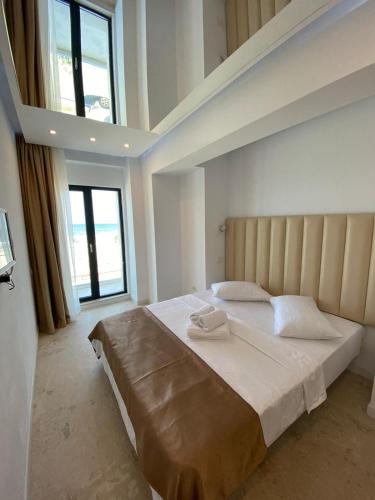 a bedroom with a large bed with two towels on it at Apartament Ella front view in Mamaia Sat/Năvodari