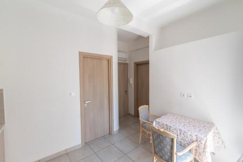 a dining room with a table and chairs and a door at Old Town Comfort by Irini in Kos Town