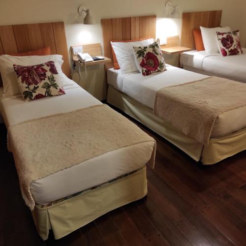 a hotel room with two beds and a telephone at Posada de las Aguilas Hotel Boutique in Ezeiza