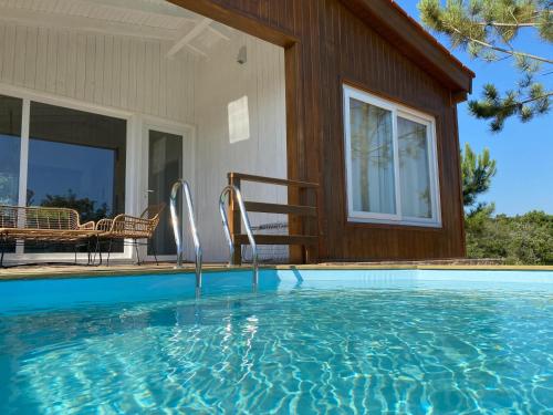 a swimming pool in front of a house at Montum Farm Living in Melides