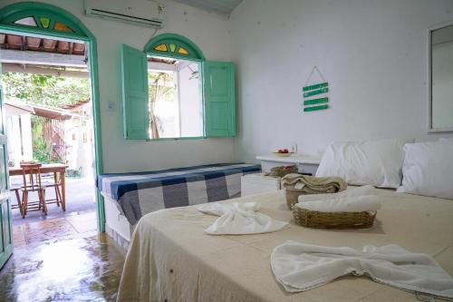 una camera con un letto e un tavolo con asciugamani di Pousada Coração do Arraial a Arraial d'Ajuda