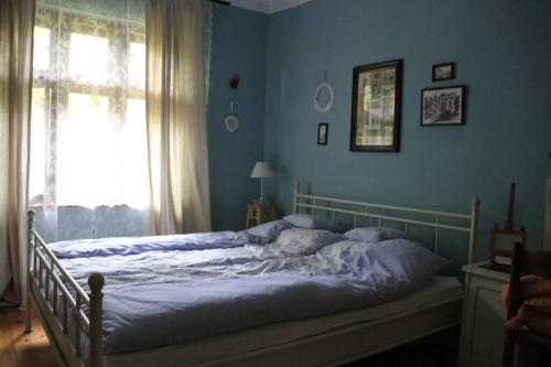 a bed in a blue bedroom with a window at Apartman Brankova kuća in Sremski Karlovci