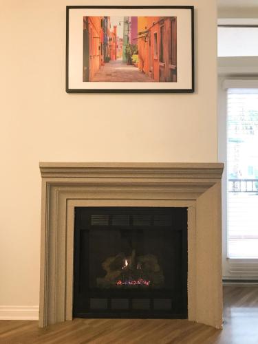a fireplace in a living room with a picture on the wall at Perfect Apt near UCLA w Parking Gym Pool WIFI in Westwood B3 in Los Angeles