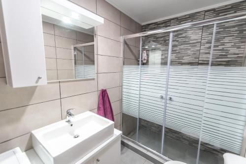 a bathroom with a sink and a glass shower at Old Town Comfort by Irini in Kos Town