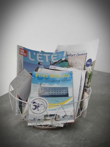 una cesta de alambre llena de periódicos y revistas en studio presqu'île Fouras proche de la plage parking privé, en Fouras