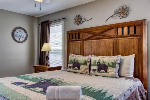 a bedroom with a large bed with a wooden headboard at River Dance by HoneyBearCabins in Sevierville