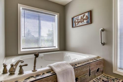 a bathroom with a tub and a window at River Dance by HoneyBearCabins in Sevierville