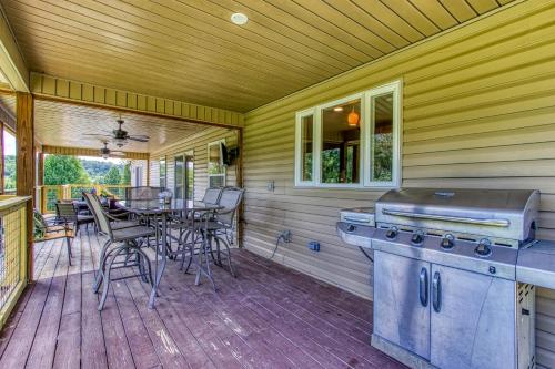 a porch with a grill and a table and chairs at River Dance by HoneyBearCabins in Sevierville