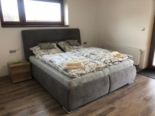 a large bed in a bedroom with wooden floors at Penzion Čavisov in Čavisov