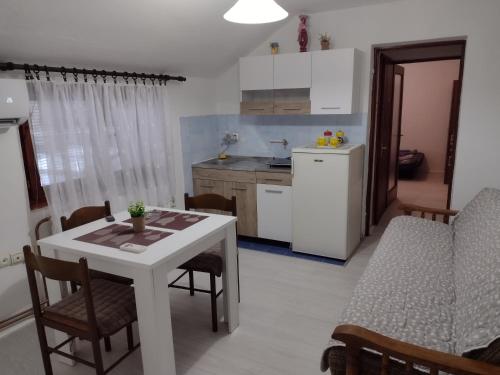 een keuken en eetkamer met een tafel en stoelen bij Apartman DM in Valjevo
