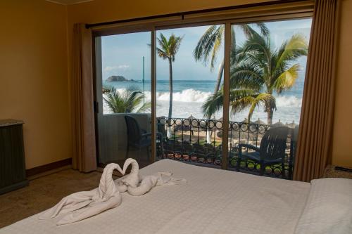 Una cama o camas en una habitación de Aca Suites Ixtapa