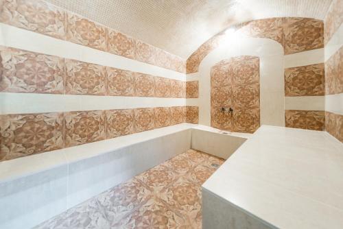 a bathroom with a tub and a tile floor at Guest House Irina in Loo
