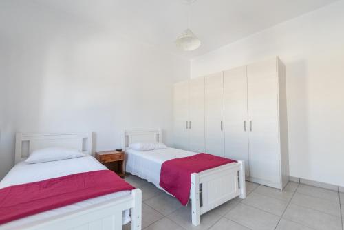 two beds in a room with white cabinets at Old Town Comfort by Irini in Kos Town