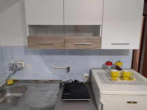 een keuken met twee gele mokken op een aanrecht bij Apartman DM in Valjevo