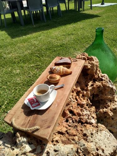 a wooden cutting board with a cup of coffee and bread at B & B Pietra Vecchia in Galatone