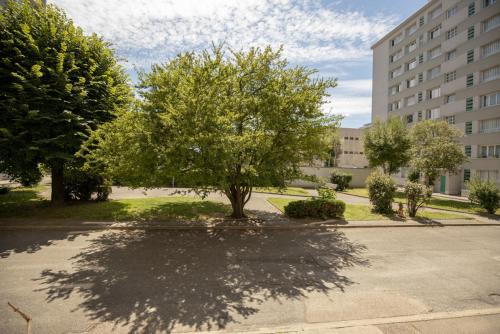 un arbre assis au milieu d'un parking dans l'établissement HOME GANUSHA COSY 3 CHAMBRES PARKING GRATUIT BALCON, à Grenoble