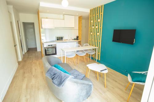 un salon avec un canapé et une table dans l'établissement HOME GANUSHA COSY 3 CHAMBRES PARKING GRATUIT BALCON, à Grenoble