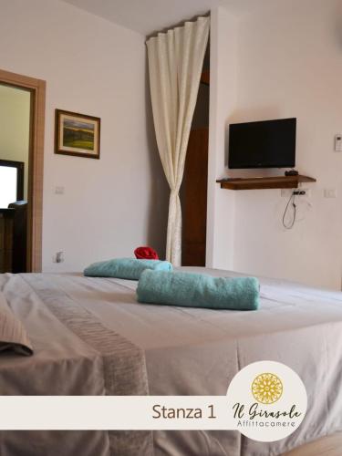 a bedroom with a bed with blue pillows on it at IL GIRASOLE in Porto Torres