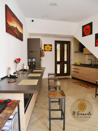 cocina con encimera y taburetes en una habitación en IL GIRASOLE, en Porto Torres