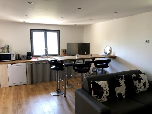 un salon avec une table et une cuisine dans l'établissement Gite du Chalet Barnabas Relais Motards, à Saint-Martin-de-la-Porte