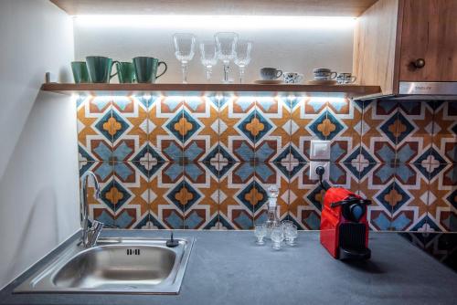 a kitchen counter with a sink and a tile wall at KRISSAIA SEASIDE SUITES in Galaxidhion