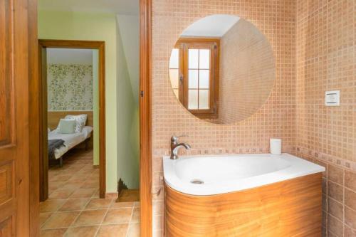 a bathroom with a tub and a round mirror at ¡Nuevo! Espectacular casa recién reformada con piscina in Bareyo