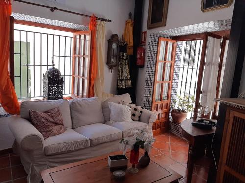 uma sala de estar com um sofá branco e janelas em Pension casa Fina Ruiz em Almuñécar