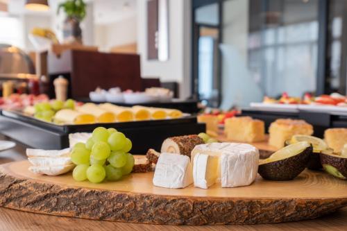 a tray of cheese and grapes on a table at Amaro Hotel in Bergkirchen