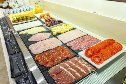 a refrigerator filled with lots of different types of food at Hotel Maestranza in Ronda