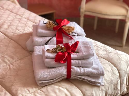 stos ręczników z czerwonymi łukami na łóżku w obiekcie Locazione in Appartamento sita in via Ponte di Ferro 2 b w mieście Gualdo Cattaneo