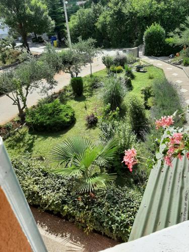 un jardín con plantas y un banco verde en Apartments ADELA, en Polje
