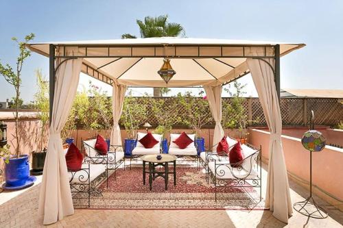 pawilon z krzesłami i stołem na patio w obiekcie Arabian Riad Marrakech w Marakeszu