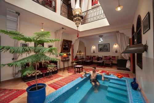 un uomo in piedi in una piscina in un soggiorno di Riad De La Semaine a Marrakech