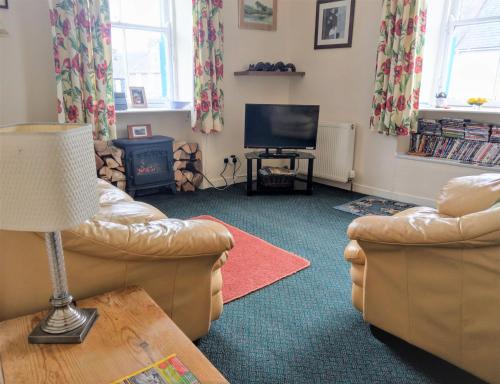 a living room with two couches and a television at 26 Castle Street in Kirkcudbright